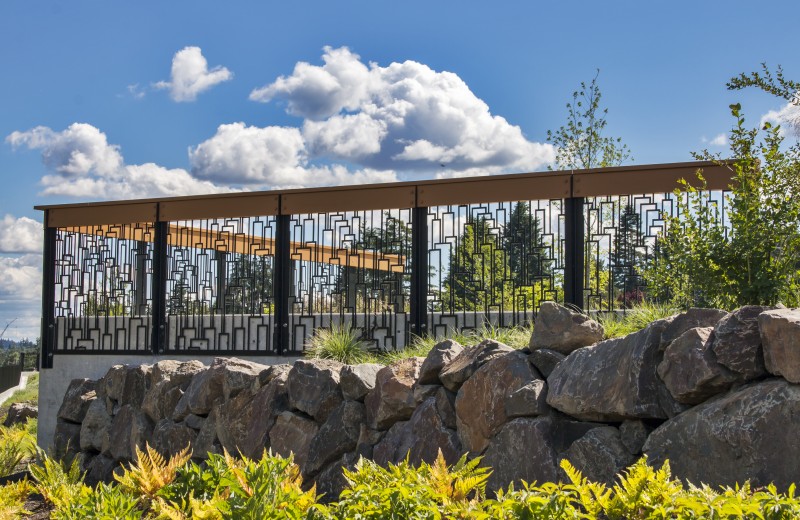 Heavy Duty Cascade Pattern Metal Railing on Rock Wall with Blue Sky Background