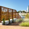 Close up of Revamp Nest Pattern Standard Corten Railing with Tall Building in Background