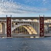 Red Nest Pattern Railing Accent Panels With 20th Century Concrete Bridge in Background